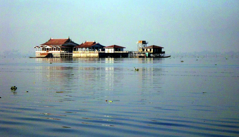 Pfahlbauten mitten im Inle-See, im morgendlichen Dunst über fast glattem Wasser